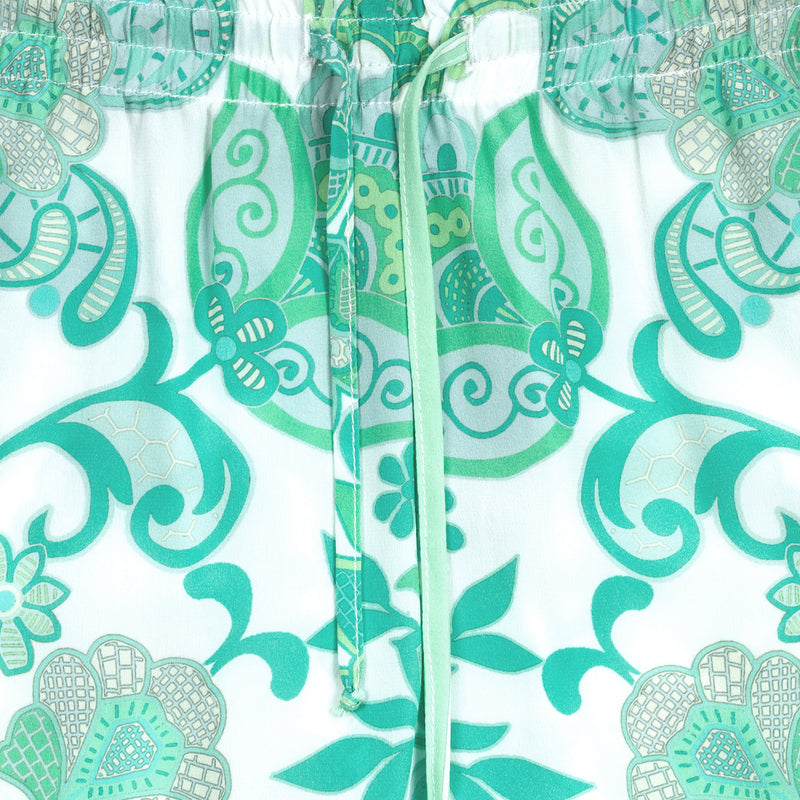 detail of a women silk pant in an emerald print